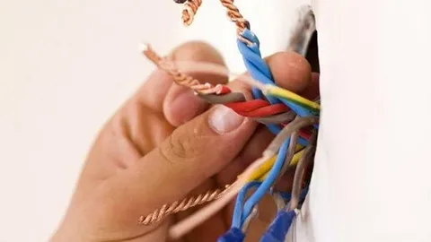Licensed emergency electrician Auckland repairing a residential electrical switchboard during an urgent service call.