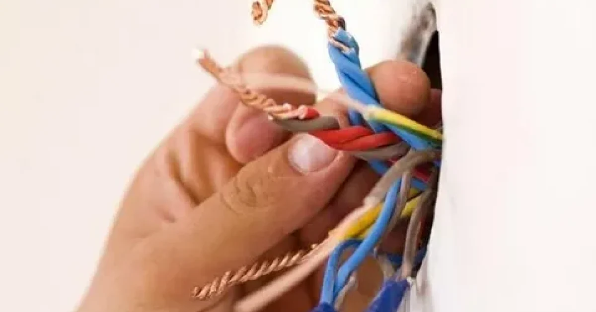 Licensed emergency electrician Auckland repairing a residential electrical switchboard during an urgent service call.